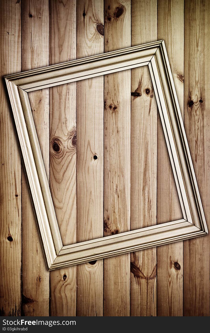 Vintage golden frame on wooden background with artistic shadows added