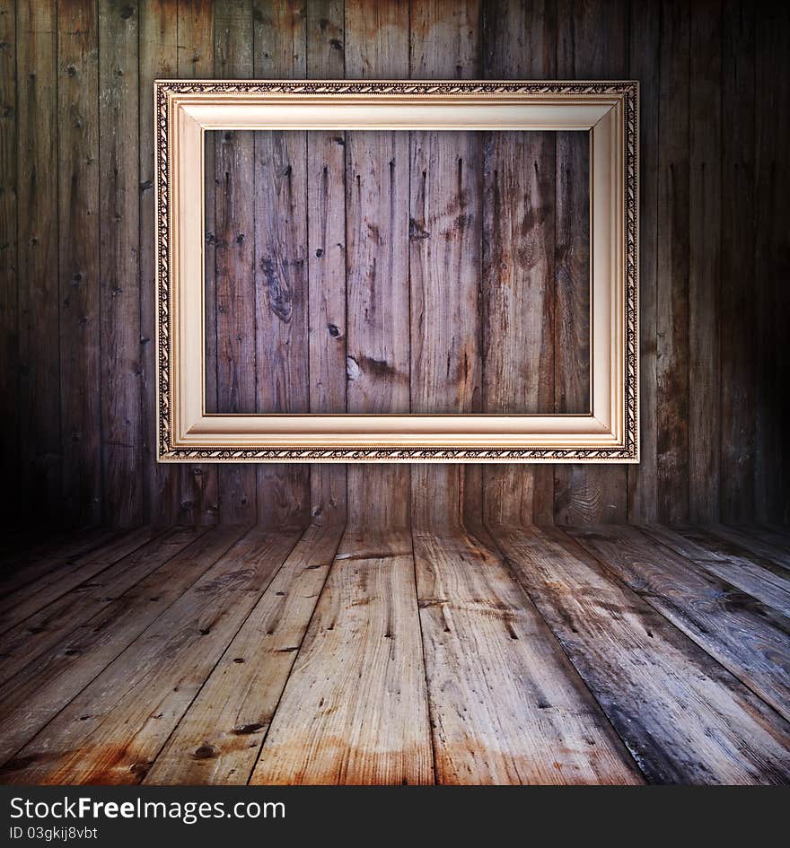 Rusty vintage wooden interior with golden frame hanging on the wall