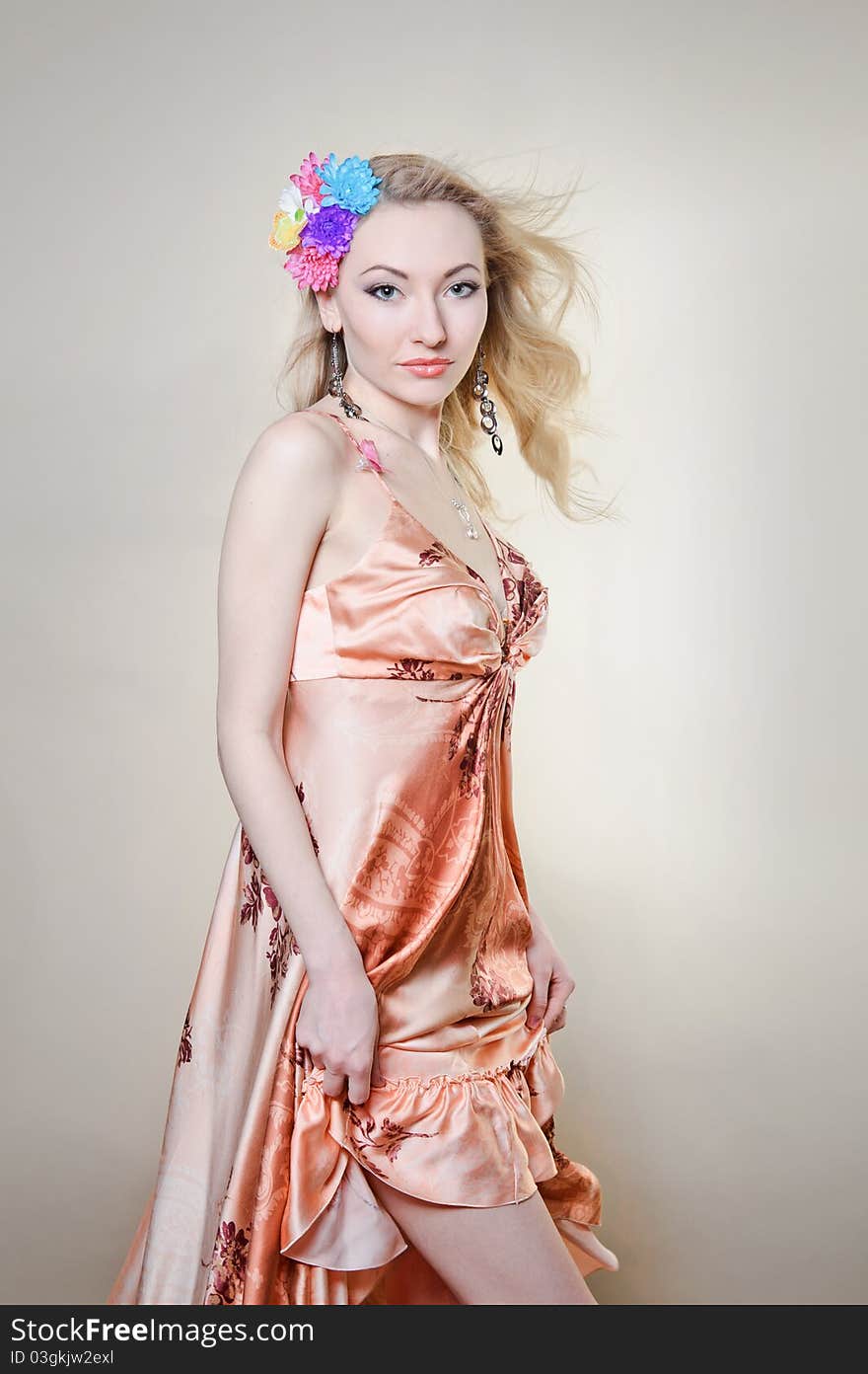 Beautiful young woman with colorful flowers in hair