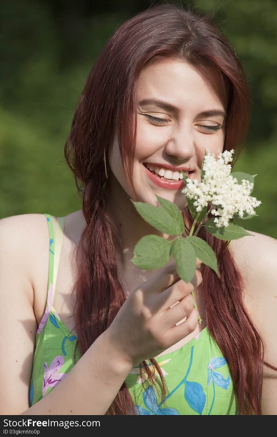 Laughing young woman with flower in a park