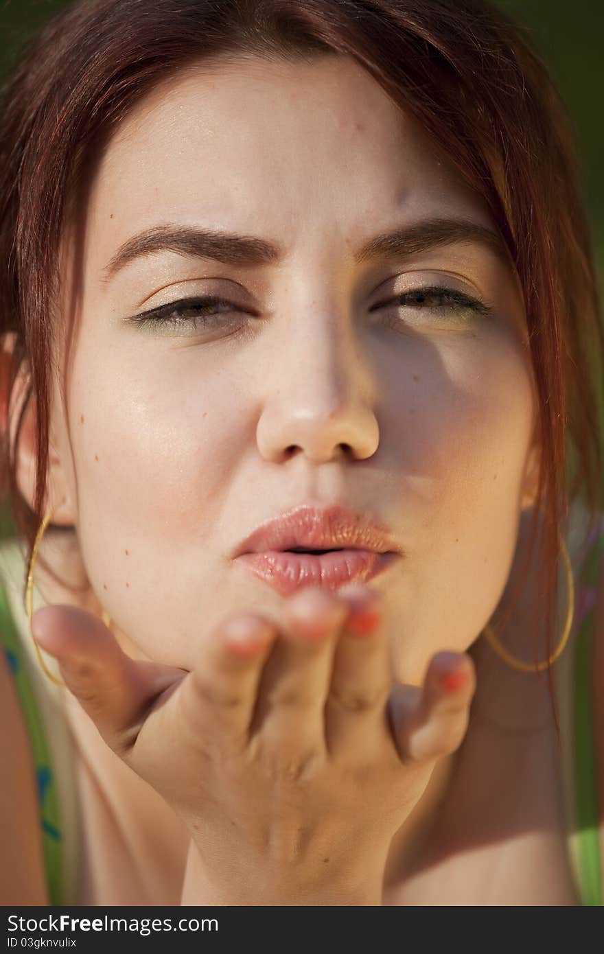 Young woman sending air kiss in camera