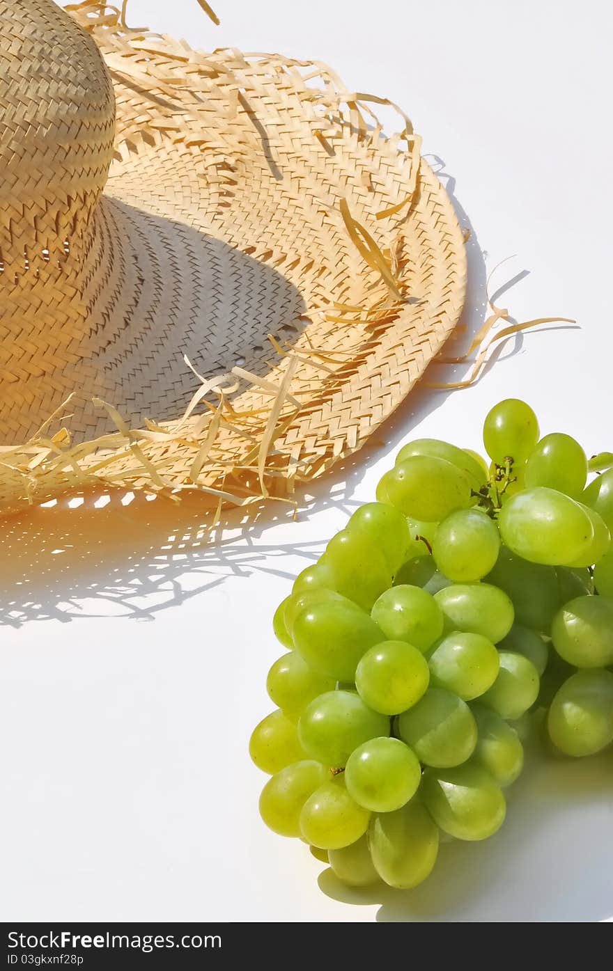 Straw hat and bunch of grapes