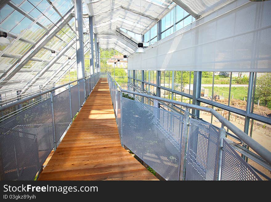 Glass greenhouse with screening and a boardwalk