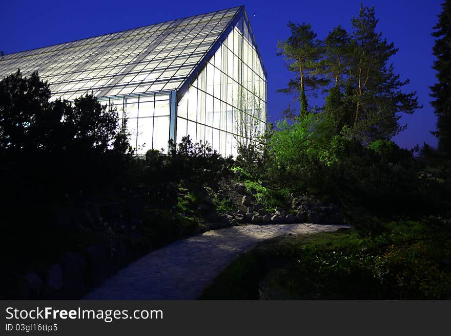 Greenhouse illuminated against night sky