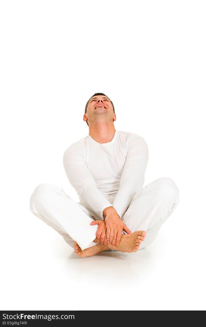 Man dressed in white sitting on the floor in white background