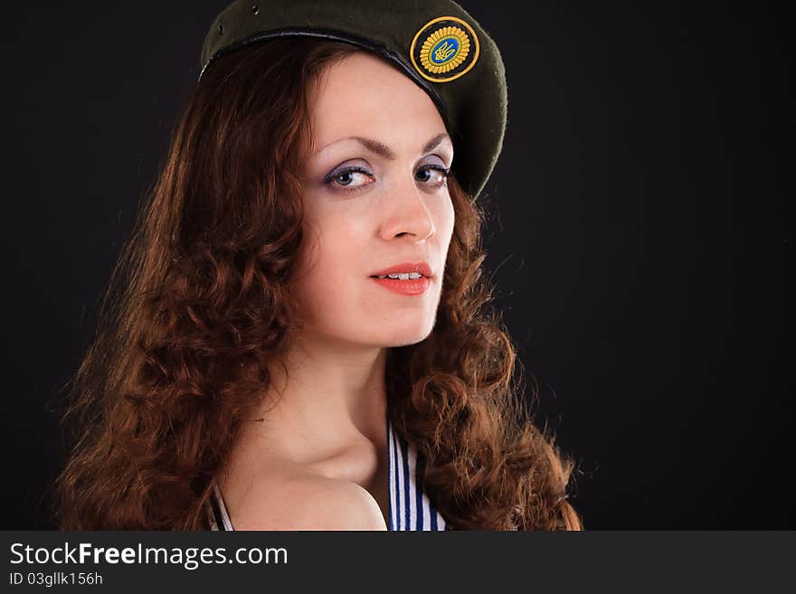 Emotional portrait of a girl in a vest and a military beret. Emotional portrait of a girl in a vest and a military beret