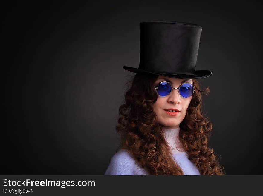 Pretty woman in blue spectacles and a black hat