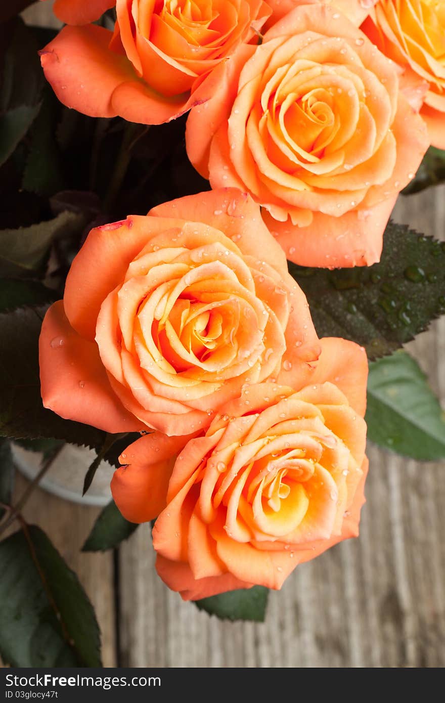 Top view on bunch of orange roses on old wooden table