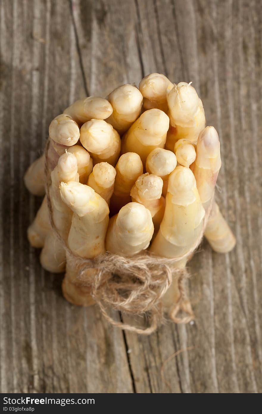 Top view on bunch of fresh white asparagus on old wooden table