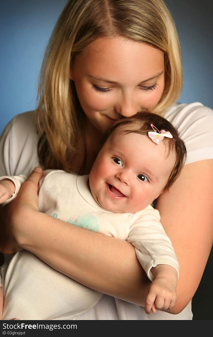 Young mother with baby on blue background. Young mother with baby on blue background