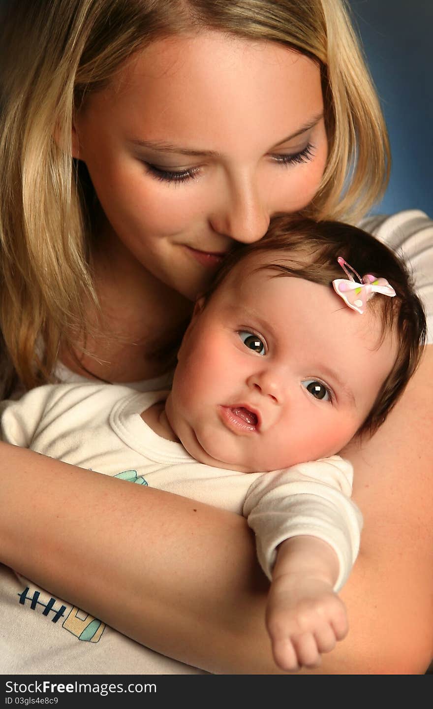 Young mother with baby on blue background. Young mother with baby on blue background