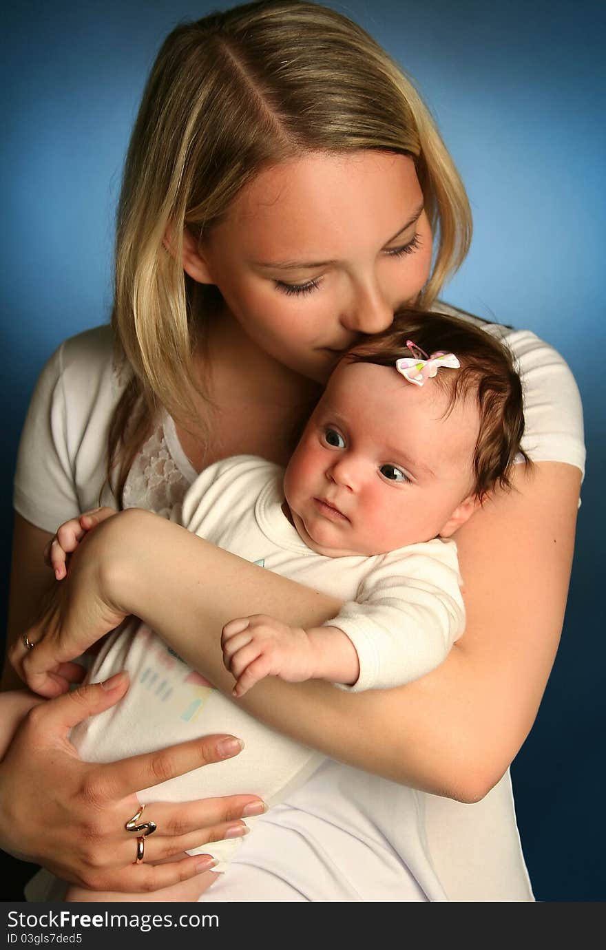 Young mother with baby on blue background. Young mother with baby on blue background