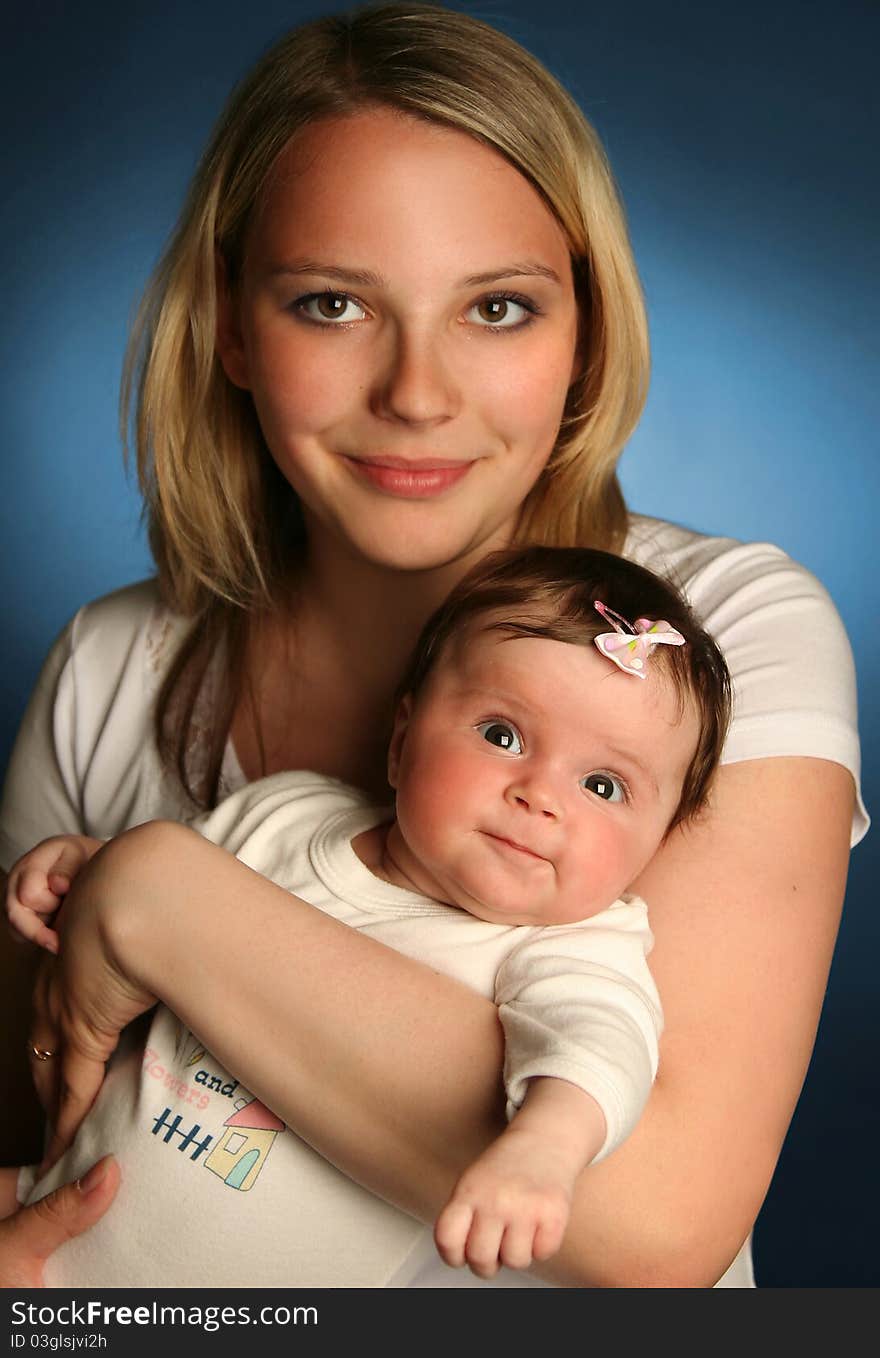 Young mother with baby on blue background. Young mother with baby on blue background