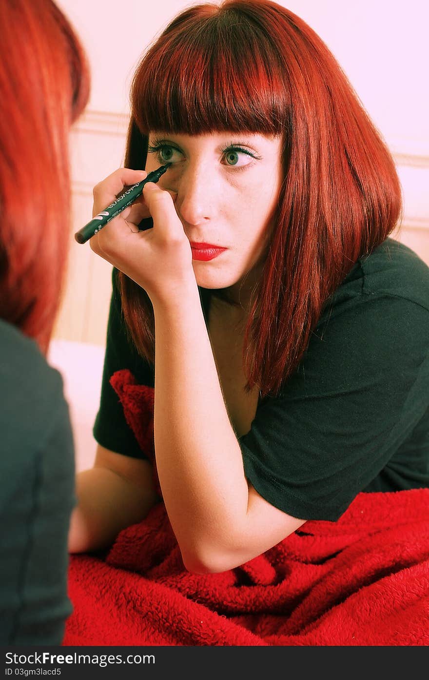 Young brunette applying make-up