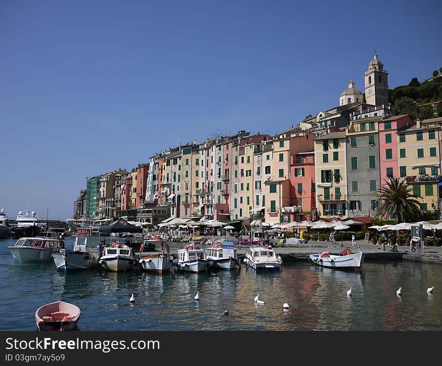 Calata Doria, in Portovenere, from the harbor, in a sunny day with reflections of the buildings in the water. Calata Doria, in Portovenere, from the harbor, in a sunny day with reflections of the buildings in the water