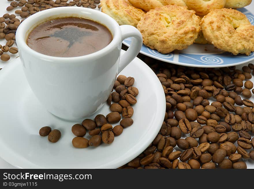 A cup of coffee with cookies and coffee beans. A cup of coffee with cookies and coffee beans