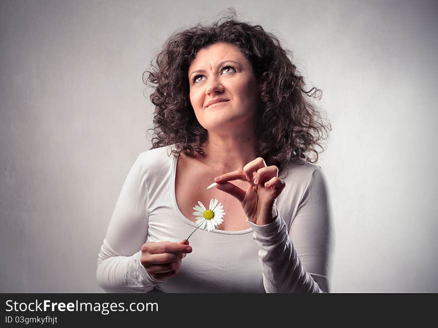 Smiling woman wavering a daisy. Smiling woman wavering a daisy