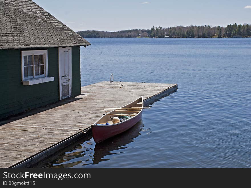 Canoe on lake docked by boat house