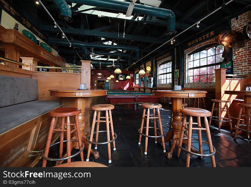 Typical irish pub with bar stools, pool tables, and a rustic feel.