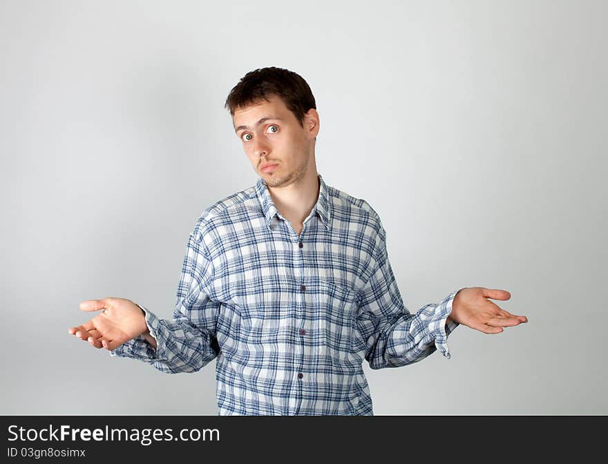 The young guy affably waves  a hand to show to someone his friendliness. The young guy affably waves  a hand to show to someone his friendliness