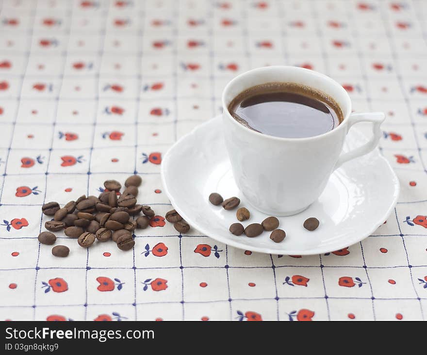 Cup of coffee and coffee beans on the table