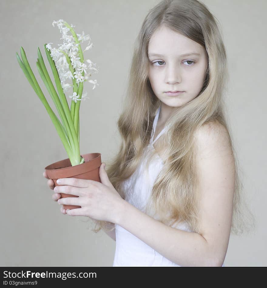 A young girl holding a pot of flowers