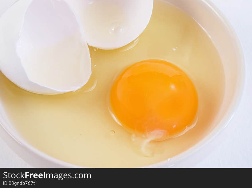 Broken chicken egg and yolk on a saucer. Broken chicken egg and yolk on a saucer