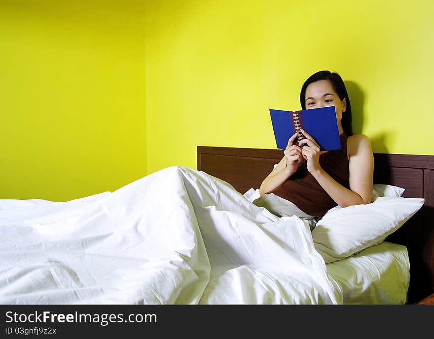 Woman reading a book in bedroom