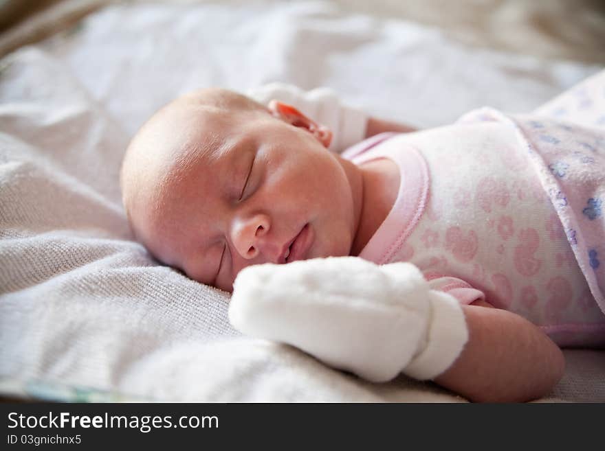 Close-up little newborn girl sleeping in her bed. Close-up little newborn girl sleeping in her bed