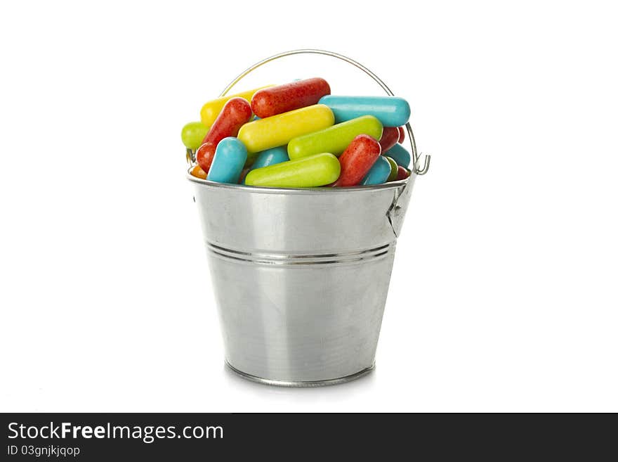 Lots of colorful flowers in a steel bucket. Isolated on white background. Lots of colorful flowers in a steel bucket. Isolated on white background