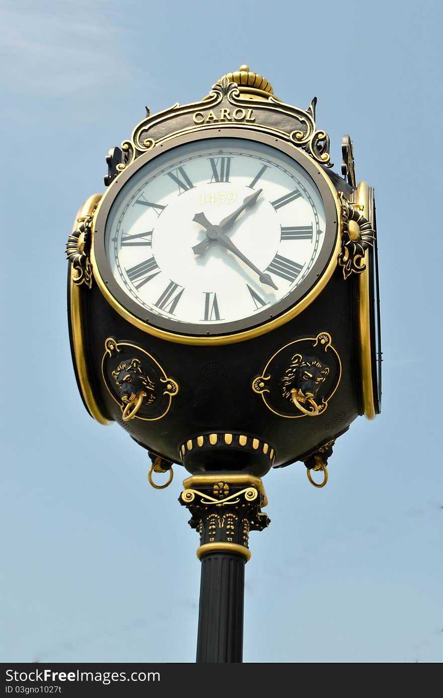 Image of a old fashion clock showing time in the middle of town. Image of a old fashion clock showing time in the middle of town