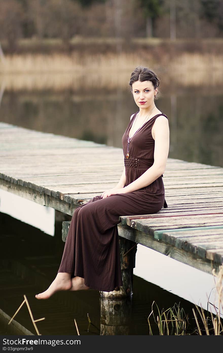 Young woman sitting on the footbridge