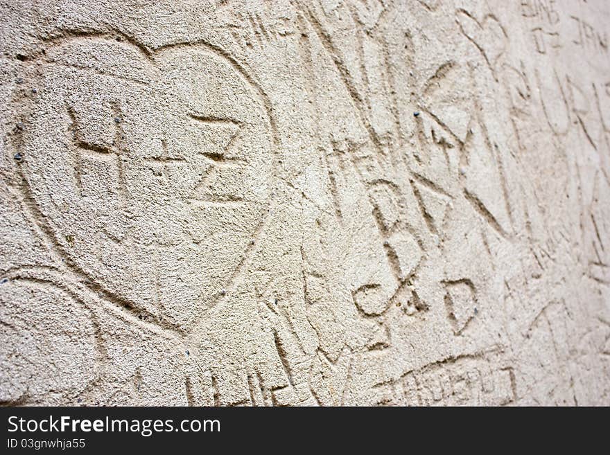 Detail of a wall engraved with love messages, pictures, letters, dates and names. Suitable as a background. Shot in Petrin, Prague.