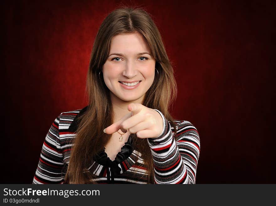 Girl pointing at you, isolated on red background