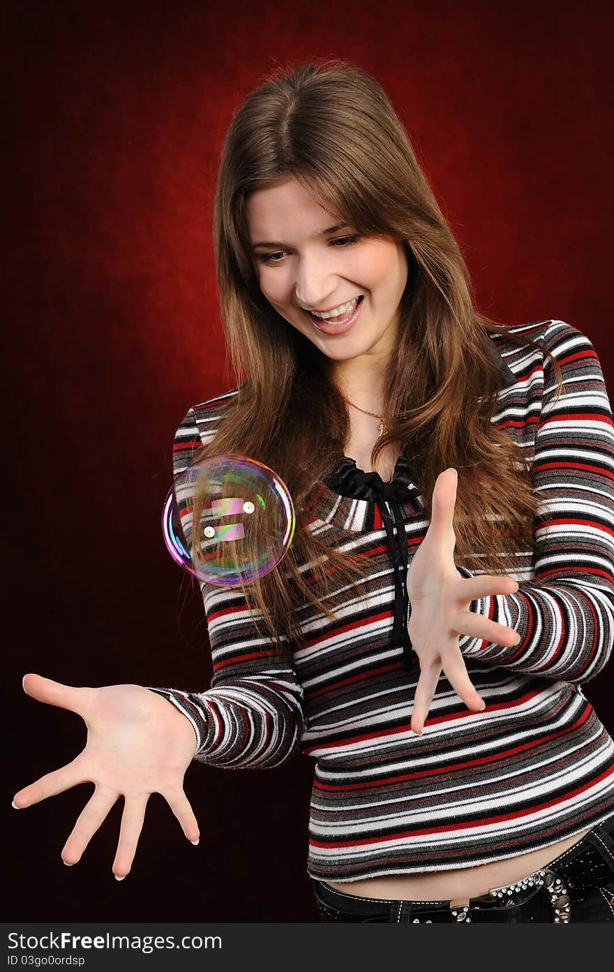 Young beautiful girl catch soap bubbles on red background. Young beautiful girl catch soap bubbles on red background