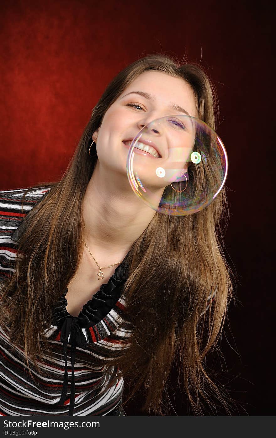 Young beautiful girl catch soap bubbles on red background. Young beautiful girl catch soap bubbles on red background