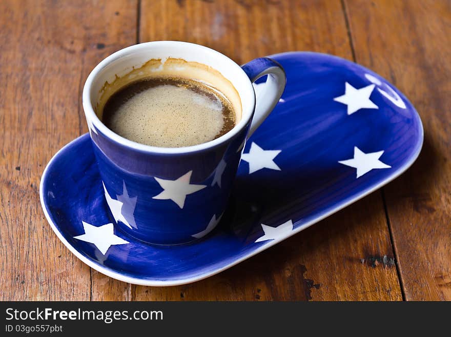 Cup of coffee and  saucer on a wooden floor