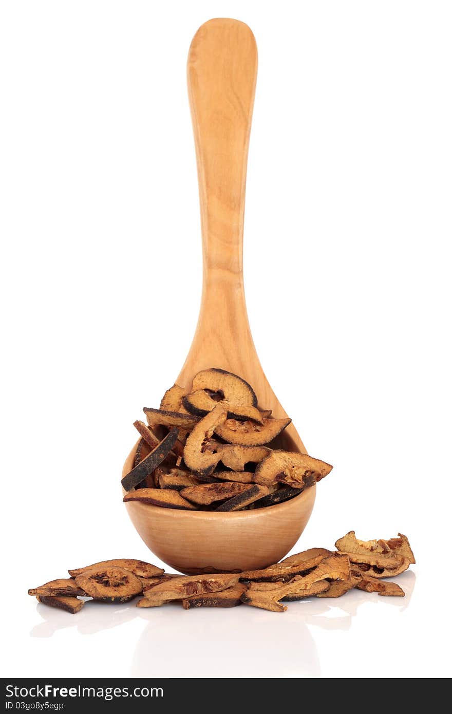 Dried bitter orange fruit in an olive wood ladle and loose, isolated over white background. Used in chinese herbal medicine. Zhi ke. Fructus citri aurantii. Focus on the fruit.