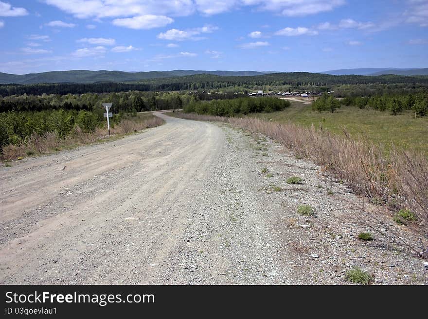 The country road conducting to a village on summer day