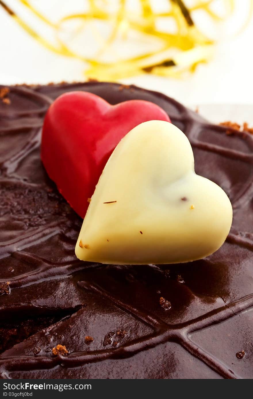 Two marzipan hearts on a chocolate icing cake