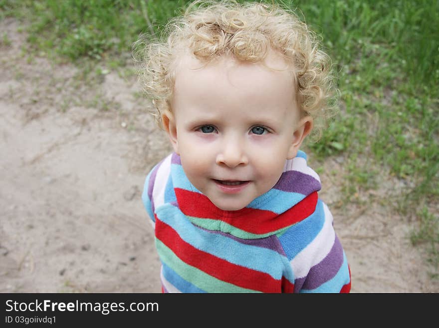 Portrait of little funny curly girl in striped blouse