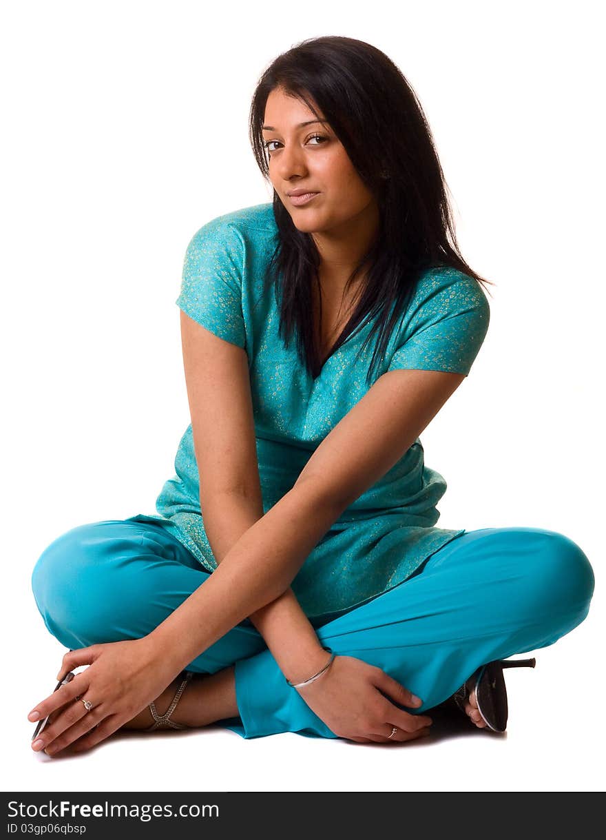 A young asian woman sitting with her legs crossed dressed in traditional clothing isolated on a white.