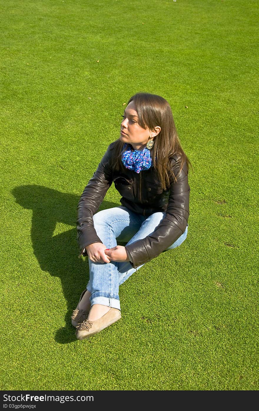 Girl Sitting On A Green Lawn