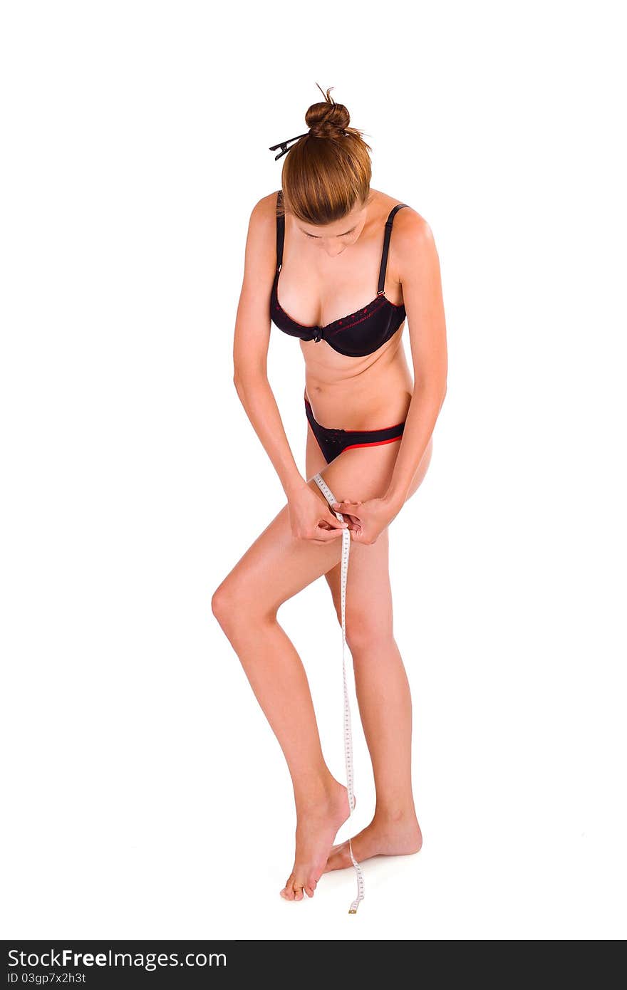 young Caucasian woman measuring her slim body