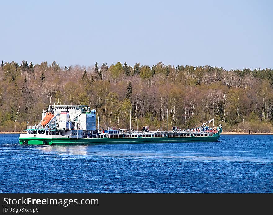 Barge on the river against the backdrop of the forest