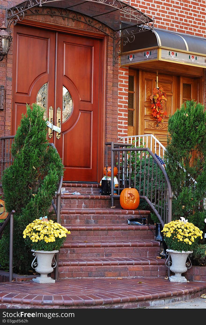 A grand main entrance of a house with halloween decoration