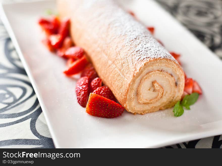 Homemade cream roulade decorated with fresh strawberries