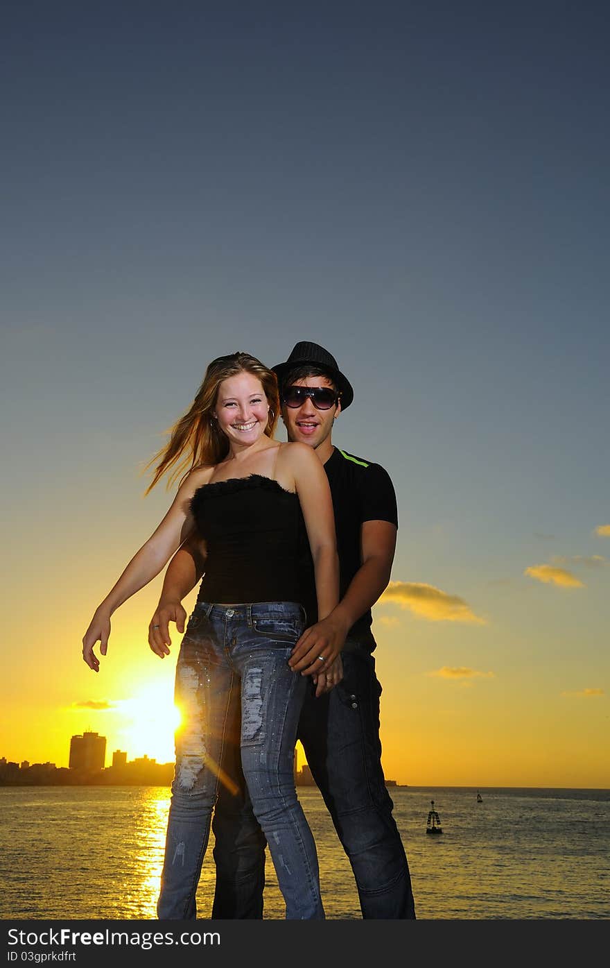 Joyful hispanic couple standing against sunset sky. Joyful hispanic couple standing against sunset sky