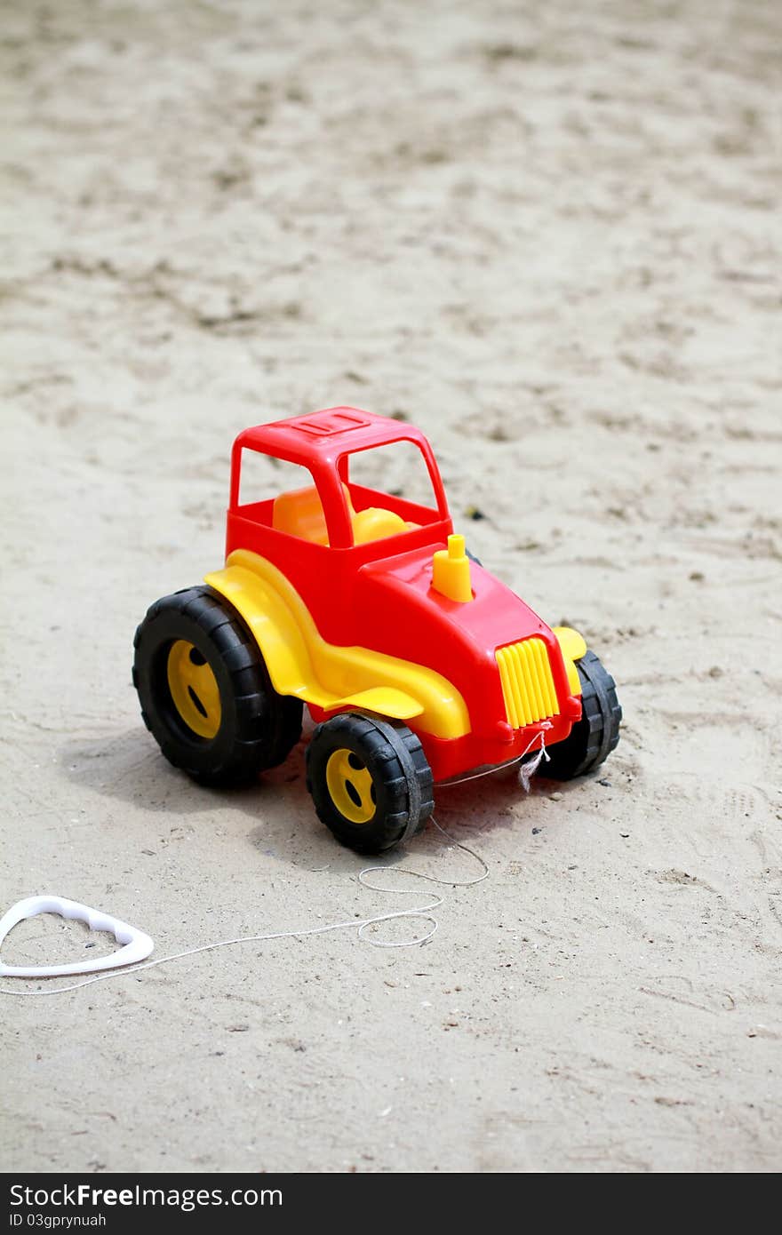 Little red toy car in sandbox