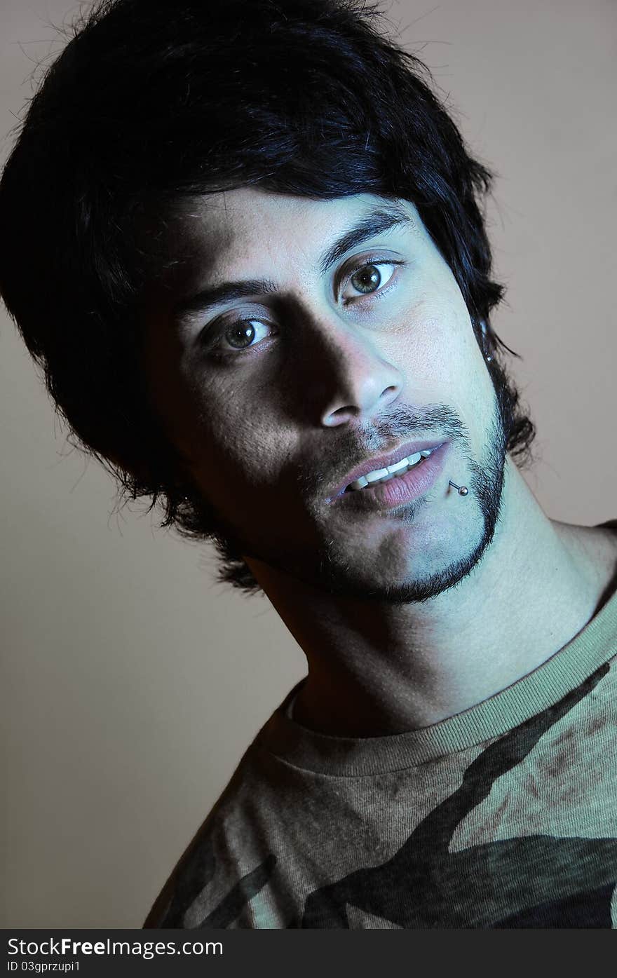 Close up portrait of young hispanic man in low key, desaturated. Close up portrait of young hispanic man in low key, desaturated.